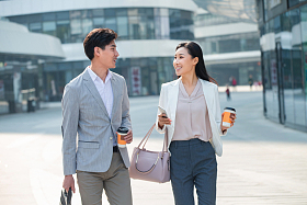 边走路边聊天的商务人士照片