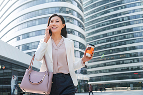 拿着咖啡的商务女性打电话