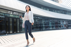 在外面步行的青年商务女人