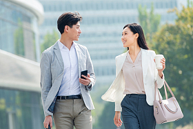 边走路边聊天的商务人士照片