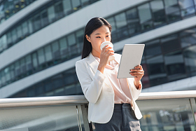 拿着平板电站在户外的商务女士