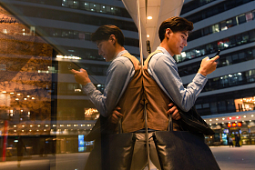 商务男士站在外面看手机