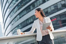 拿着平板电站在户外的商务女士