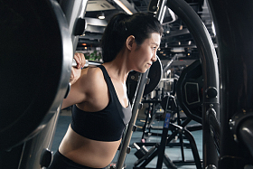 健身房里年轻女子在练习举杠铃