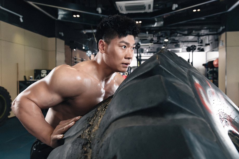 年轻男子在健身房做翻轮胎练习 年轻男子在健身房做翻轮胎练习