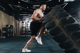 年轻男子在健身房做翻轮胎练习