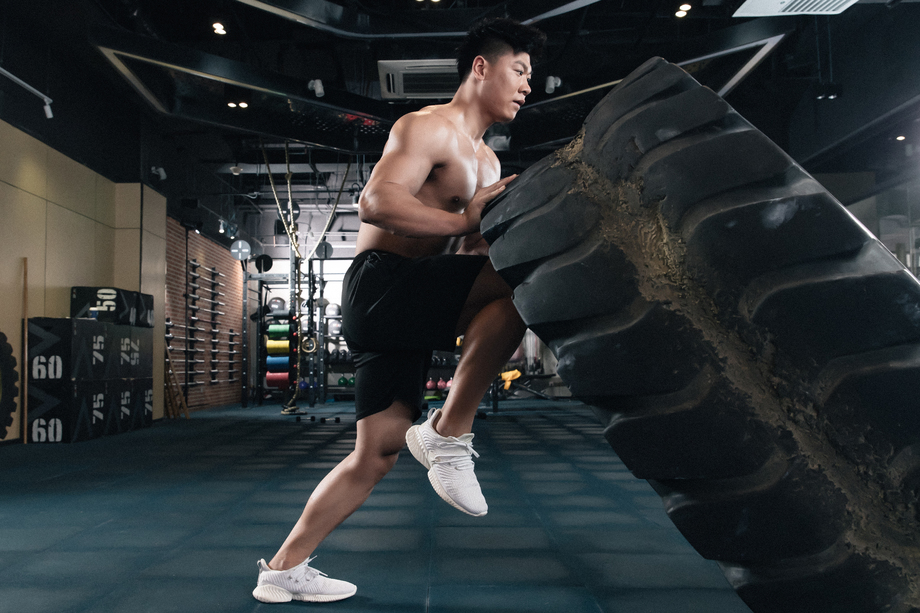 年轻男子在健身房做翻轮胎练习