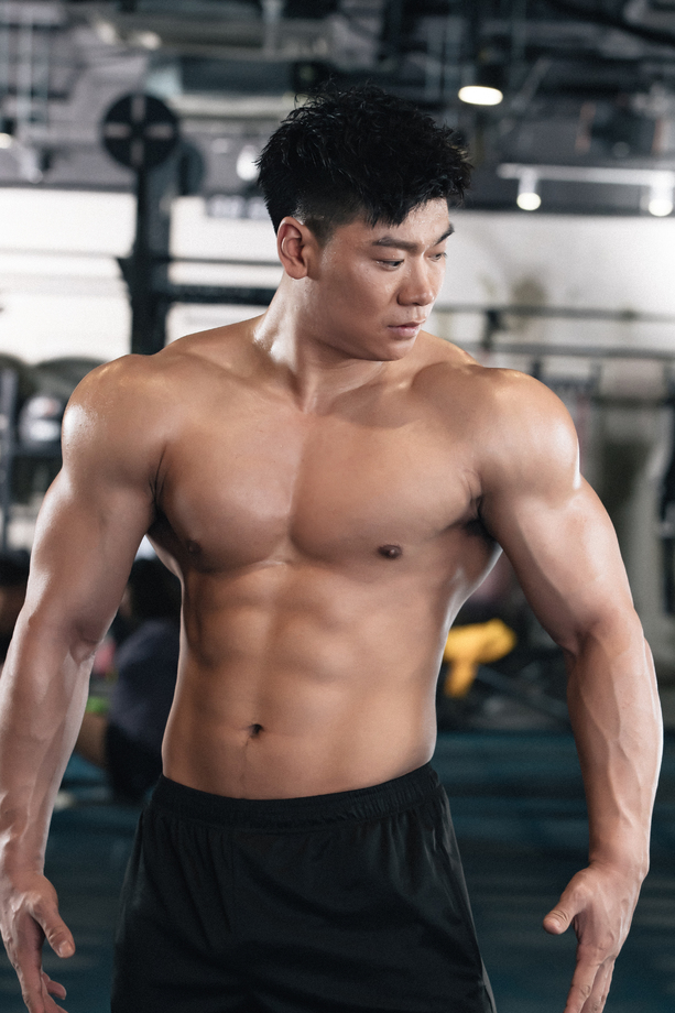 年轻男子在健身房展示肌肉 年轻男子在健身房展示肌肉