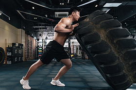 年轻男子在健身房做翻轮胎练习