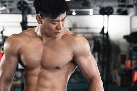 年轻男子在健身房展示肌肉照片