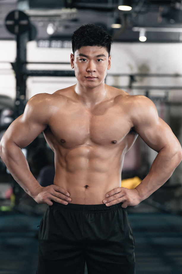 年轻男子在健身房展示肌肉