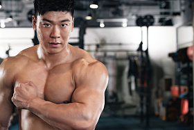 年轻男子在健身房展示肱二头