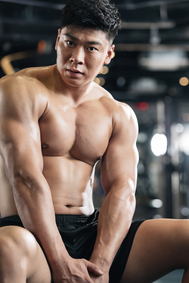 年轻男子在健身房坐着休息 年轻男子在健身房坐着休息