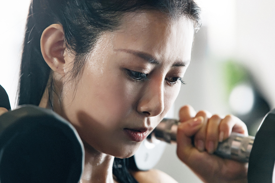 年轻女子在健身房练习举哑铃