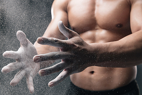 健美运动员的手和空气中漂浮的镁粉