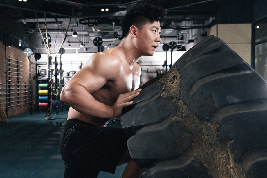 年轻男子在健身房做翻轮胎练习 年轻男子在健身房做翻轮胎练习