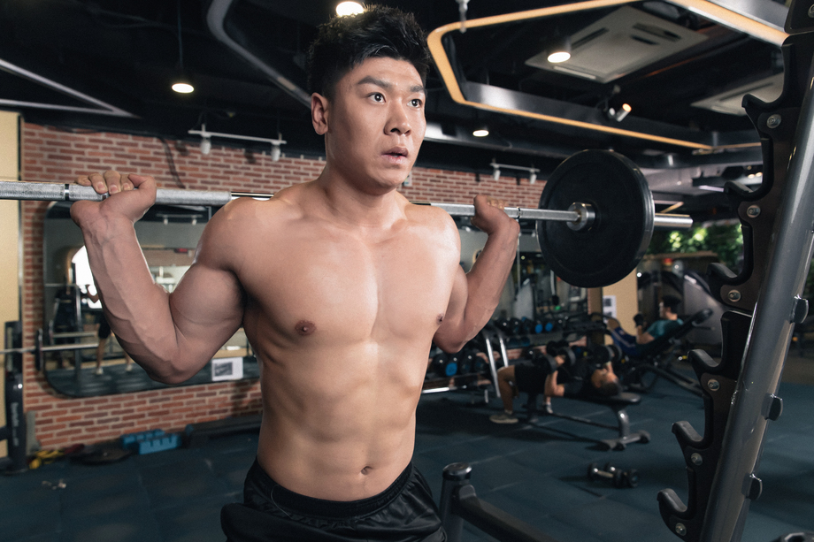 年轻男子在健身房练习举杠铃 年轻男子在健身房练习举杠铃
