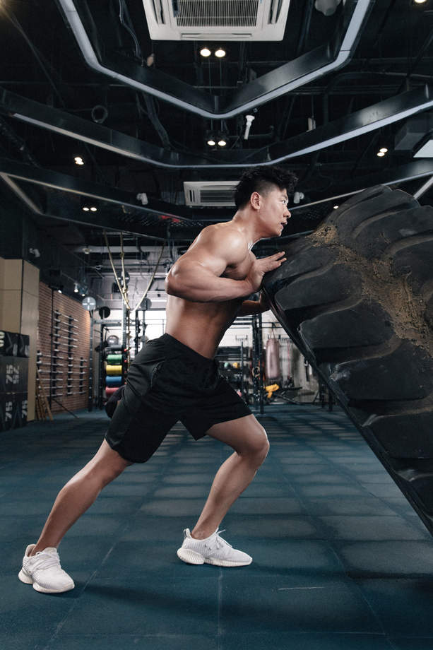 年轻男子在健身房做翻轮胎练习 年轻男子在健身房做翻轮胎练习