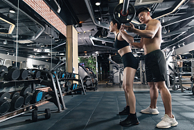 年轻女子在教练指导下举杠铃照片