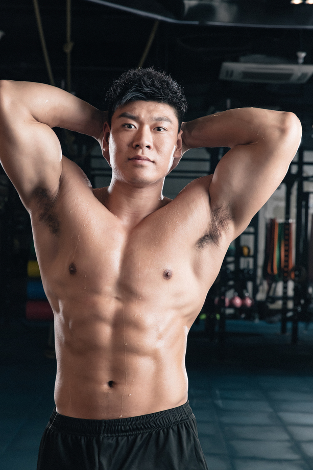 年轻男子在健身房展示肌肉图片