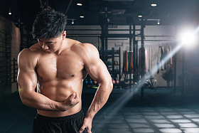 年轻男子在健身房展示肌肉照片