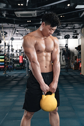 健身馆内年轻男人拿着壶铃图片