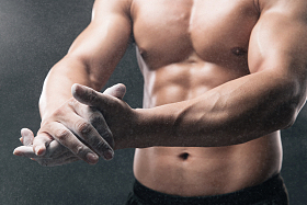 健美运动员的手在涂抹滑石粉