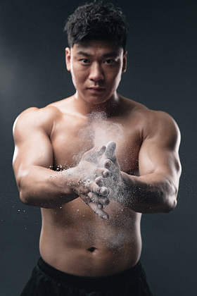 举重运动员往手上涂抹滑石粉图片