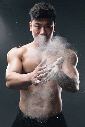 举重运动员往手上涂抹滑石粉图片