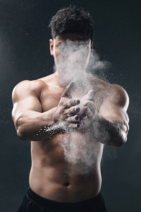 举重运动员往手上涂抹滑石粉图片