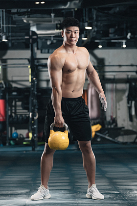 健身馆内年轻男人拿着壶铃图片