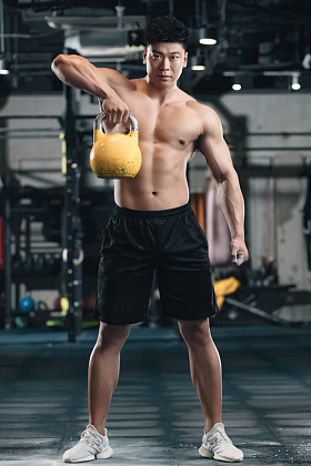 健身馆内年轻男人拿着壶铃图片