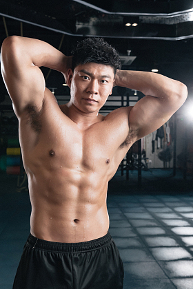 年轻男子在健身房展示肌肉照片