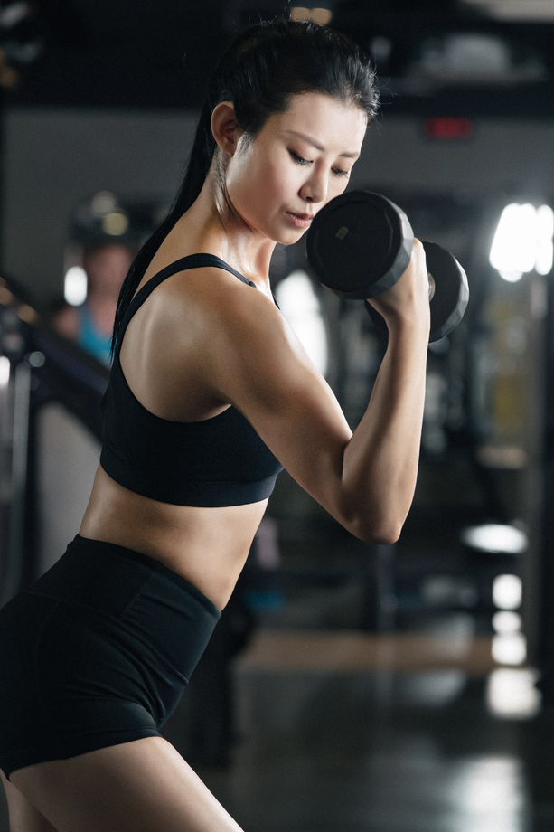 年轻女子在健身房举哑铃照片