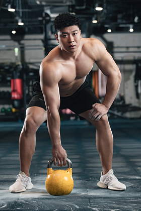 健身馆内年轻男人拿着壶铃图片