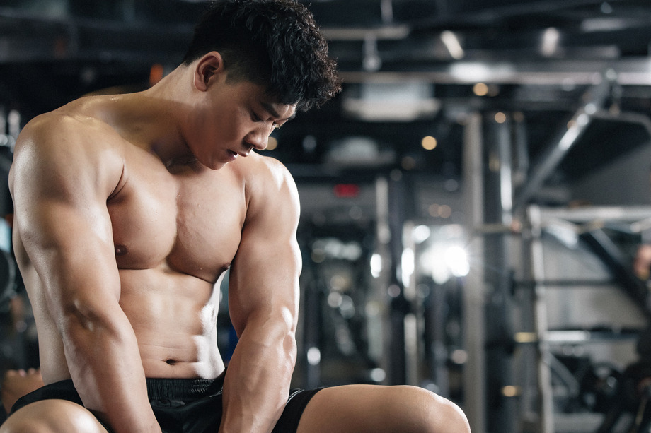 年轻男子在健身房坐着休息 年轻男子在健身房坐着休息