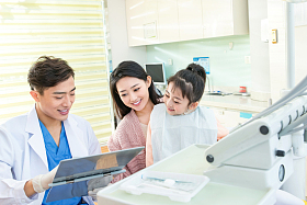 年轻妈妈带着小女孩看牙医图片