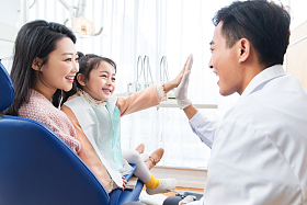 年轻妈妈带着小女孩看牙医照片