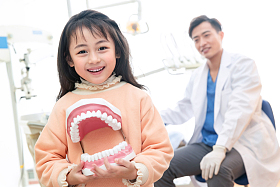 可爱的小女孩和牙科医生