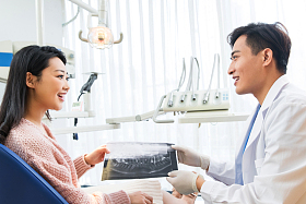 牙医和青年女患者交谈照片