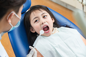 可爱的小女孩和牙科医生照片