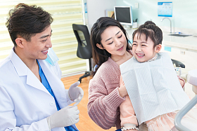 年轻妈妈带着小女孩看牙医
