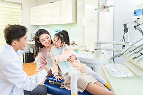 年轻妈妈带着小女孩看牙医