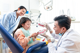 牙科医生教小女孩刷牙