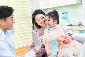 年轻妈妈带着小女孩看牙医