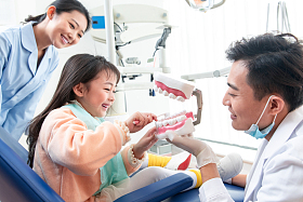 牙科医生教小女孩刷牙