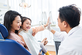 年轻妈妈带着小女孩看牙医