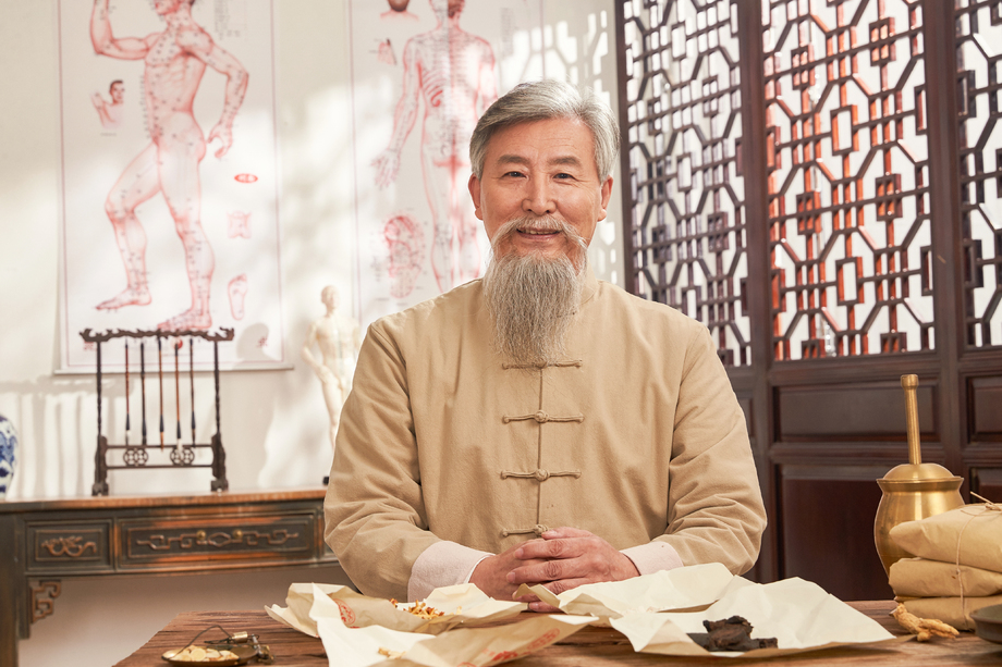 老中医坐在药桌后的肖像图片