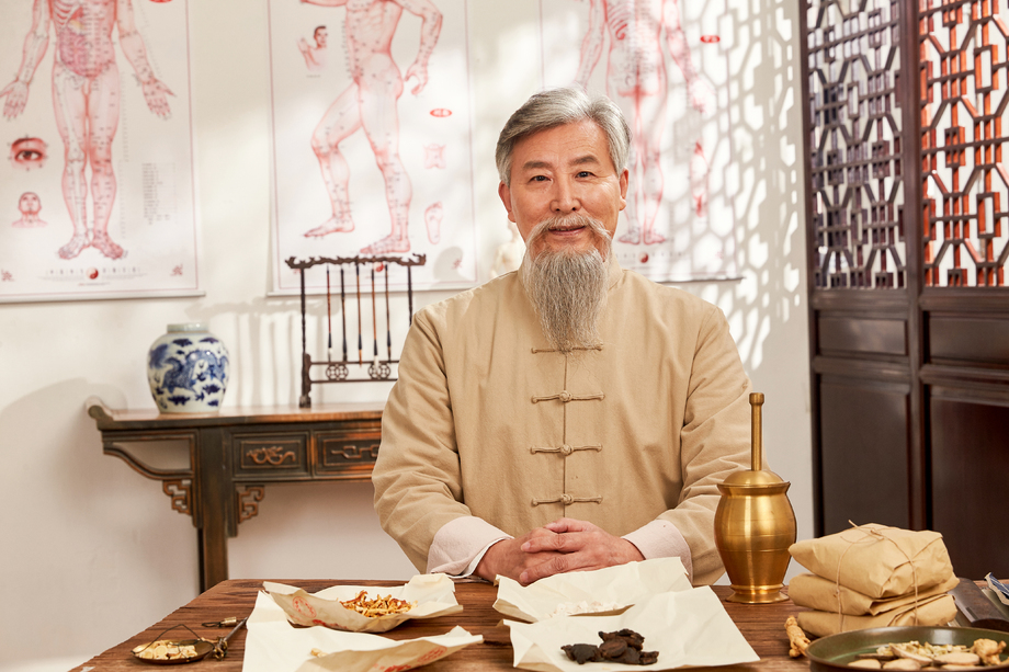 老中医坐在药桌后的肖像图片