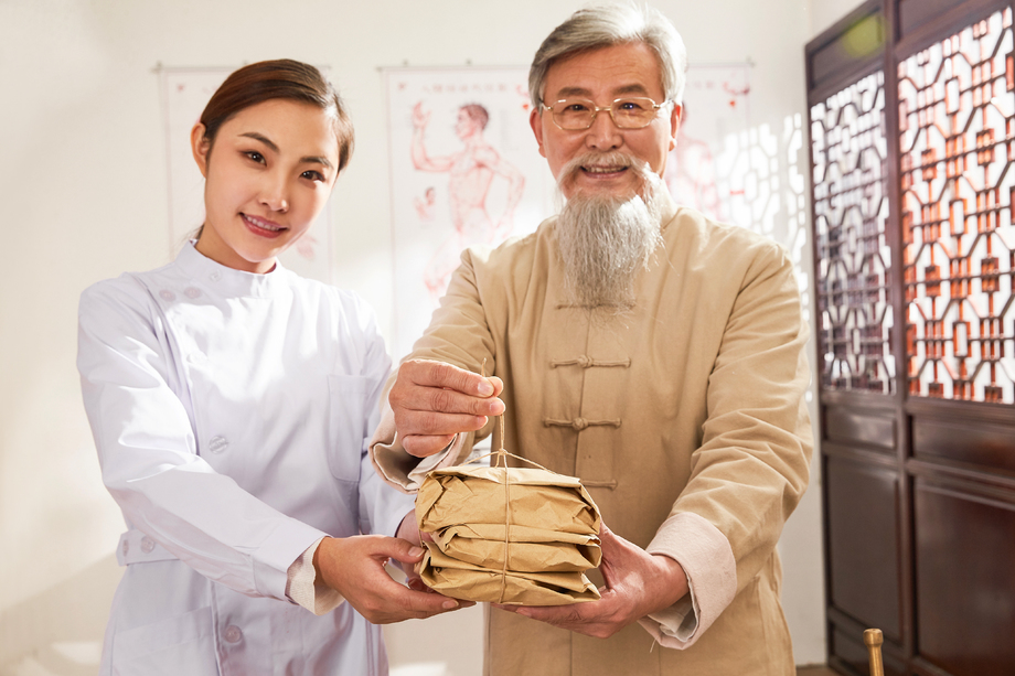 老中医和年轻医生拿着药包 老中医和年轻医生拿着药包